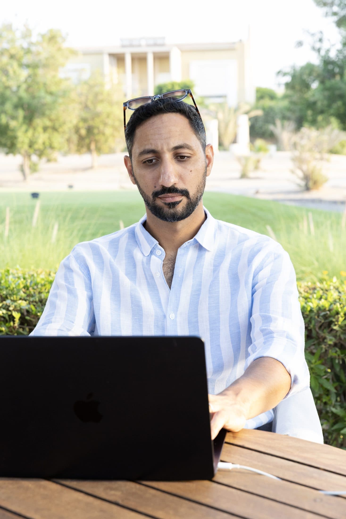 Ahmed Gheith working on a laptop outdoors